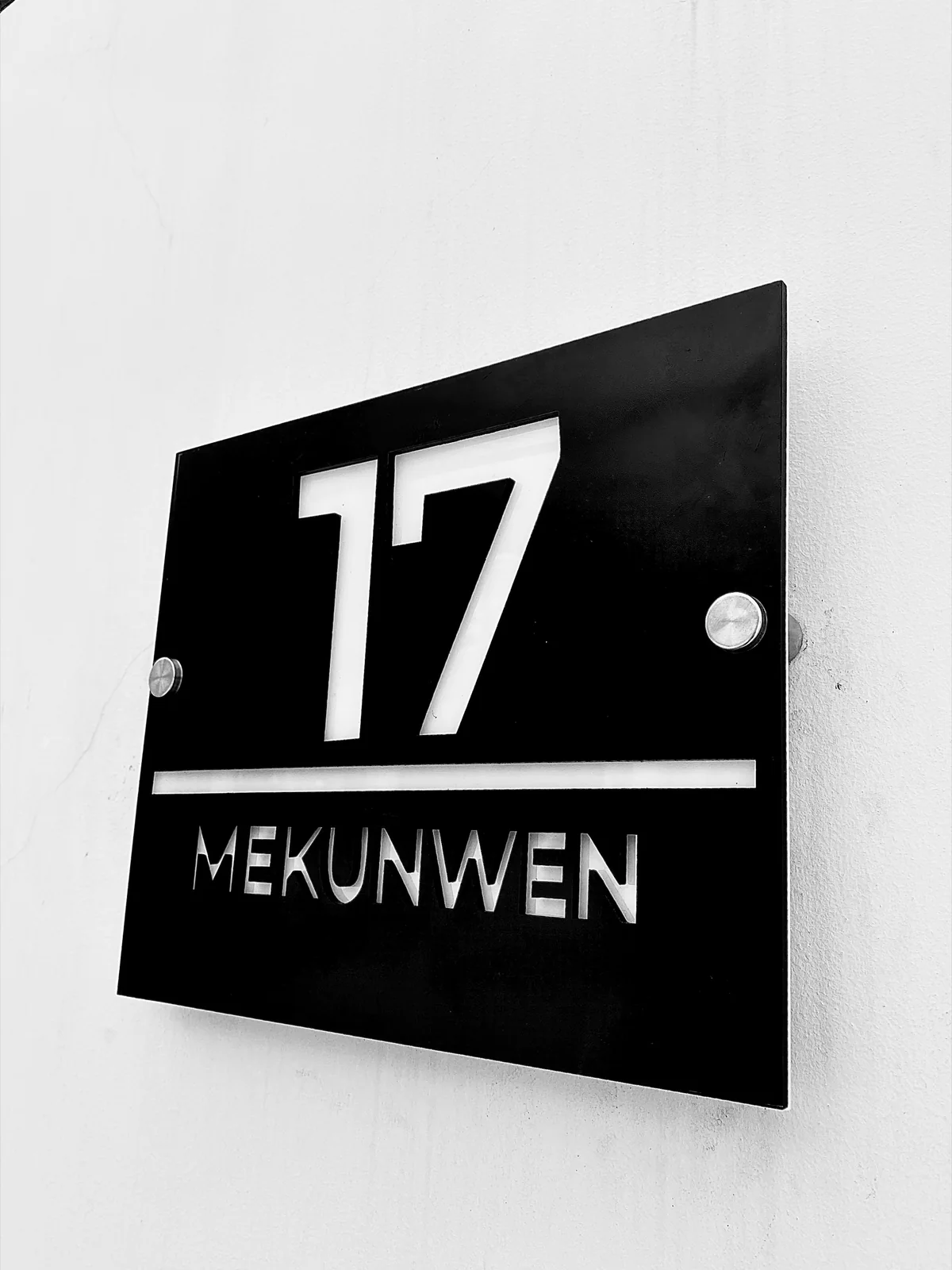 The 17 Mekunwen address plaque in white on black, mounted at the entrance